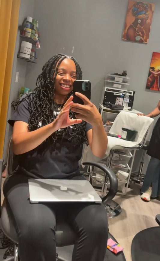 Destini Miller smiling with her braids, showing self-care and joy as part of her healing journey after pregnancy loss